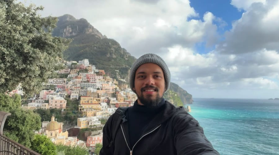 Elio taking a selfie above the colourful houses of Positano and the sea.