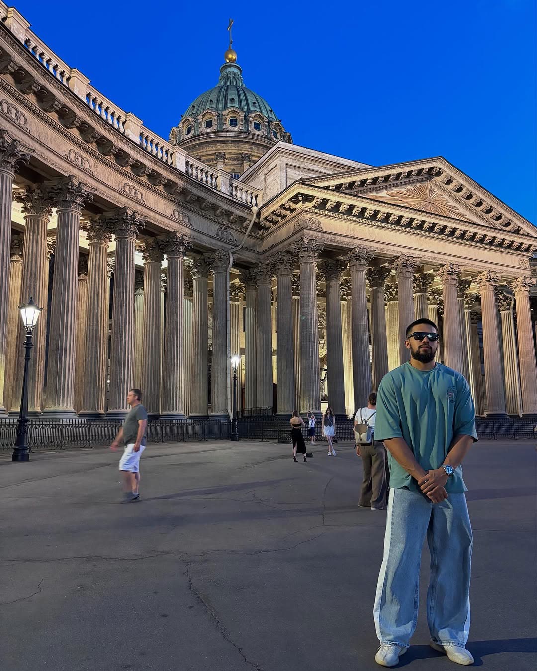 Elio in front of a domed colonnade at dusk.